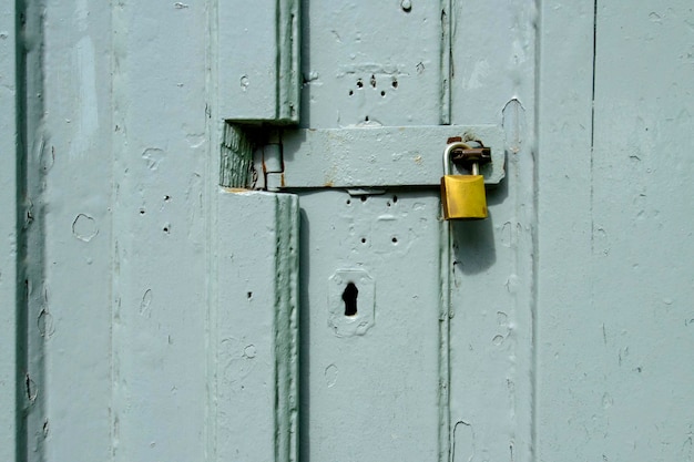 Foto vorhängeschloss an einem grauen holztor, das einen strukturierten hintergrund bildet