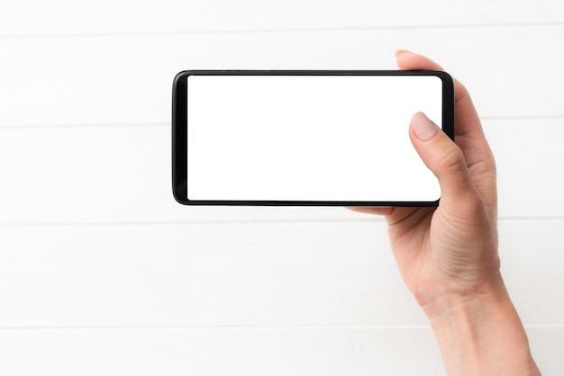 Vorlage für die Verwendung eines schwarzen Smartphones auf weißem Tischhintergrund für Ihr Design