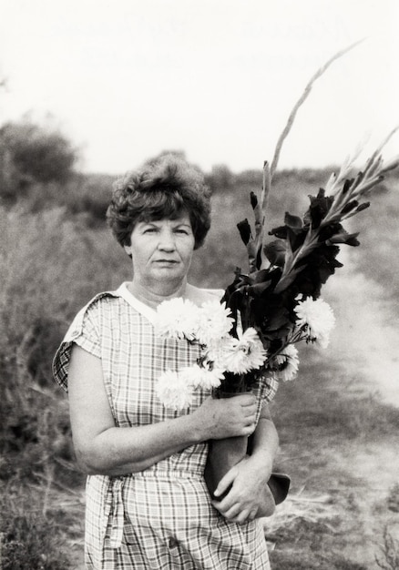 Foto voronezh urss 05151985 foto vintage de una mujer mayor atractiva con un ramo de flores