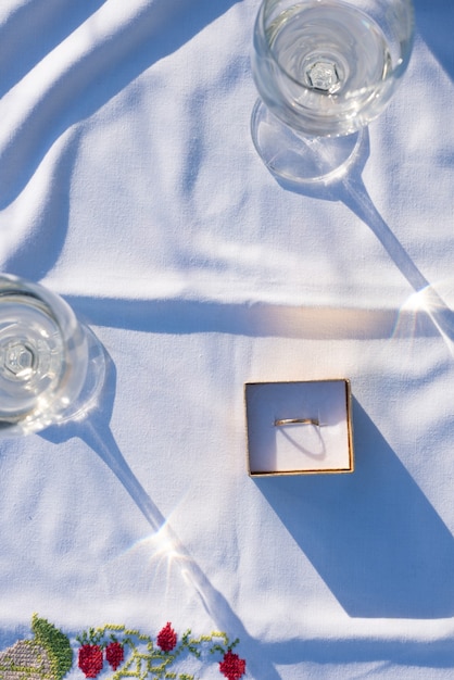 Foto vorschlag konzept schreibtisch mit wein und goldenen verlobungsring flach legen