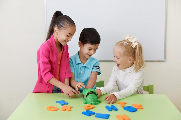 Vorschulkinder spielen mit Buchstaben auf einem Schreibtisch