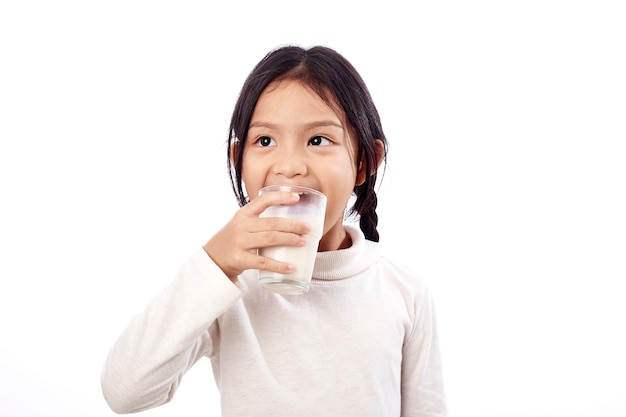 Vorschulmädchen, das ein Glas mit Milch hält