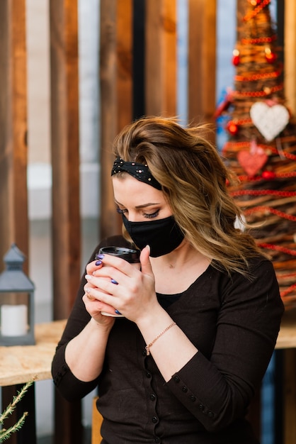 Vorsichtsmaßnahmen an öffentlichen Orten nach Beendigung der Quarantäne. Junge Frau mit medizinischer Maske im Café