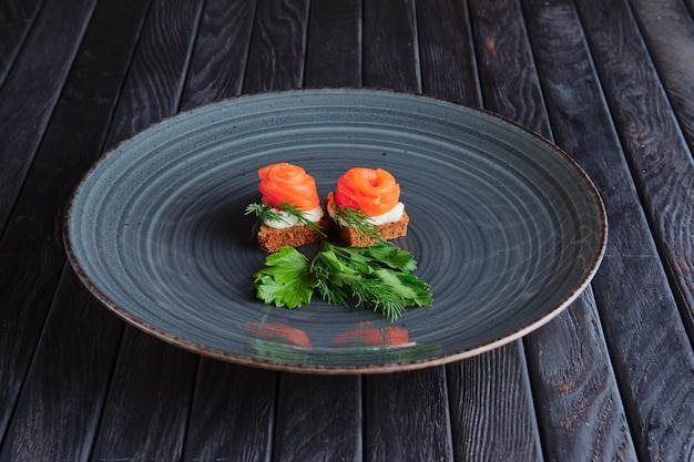 Vorspeise für den Empfang. Geräucherter Lachs mit Ricotta und Dill auf Stück Schwarzbrot