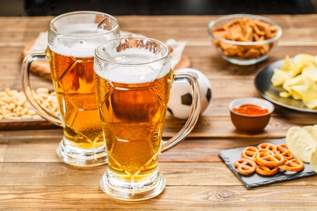 Vorspeisen und bier auf dem tisch für die fußballparty und schauen sie sich das fußballspiel an.