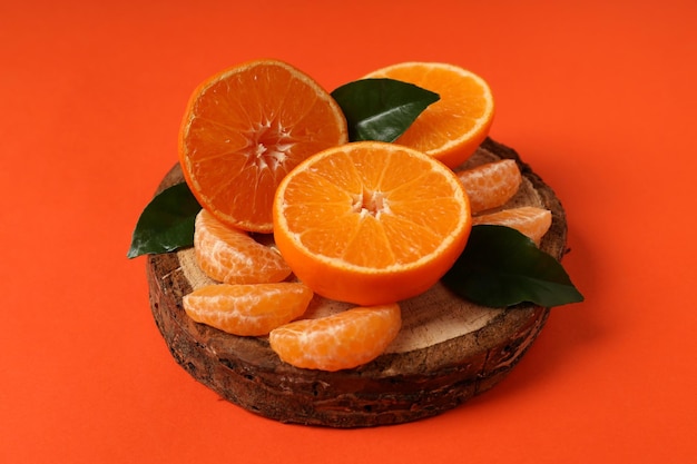Vorstand mit Mandarine und Blätter auf orangefarbenem Hintergrund