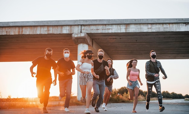 Vorwärts rennen Gruppe junger, fröhlicher Freunde, die gemeinsam Spaß haben Party im Freien