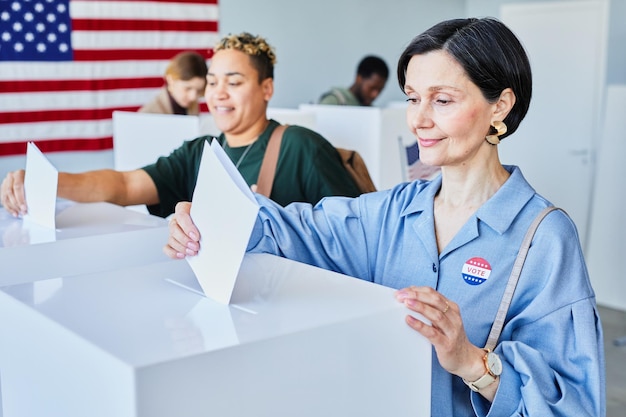 Votantes poniendo papeletas en la papelera