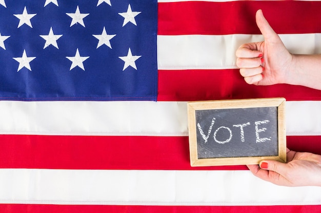 Voto firmar en la pizarra junto a la bandera americana.