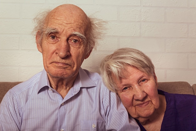 Vovó e vovô muito velhos se abraçando no sofá amor na velha esposa coloca a cabeça no ombro do marido pessoas idosas