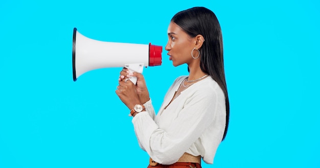 Foto voz de megafone e anúncio de mulher isolada em fundo azul transmitindo notícias de última hora e opinião alta pessoa indiana com som de alto-falante para estilo de vida gen z ou sinal de chamada para ação no estúdio