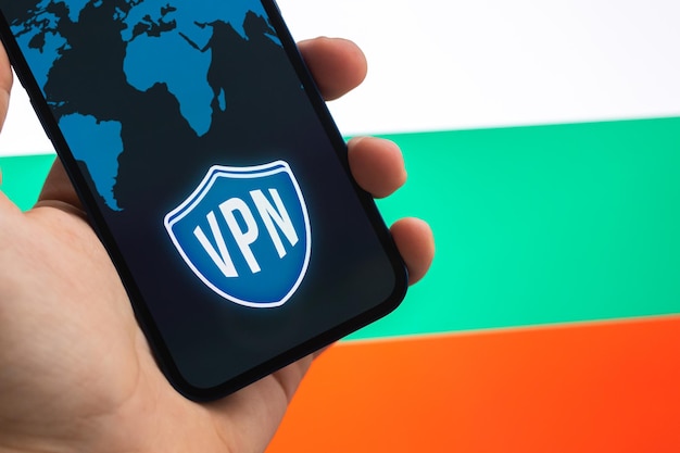 VPN en Bulgaria Concepto de Internet seguro y seguro Privacidad Mano con teléfono móvil y aplicación VPN Bandera y computadora portátil en la foto de fondo