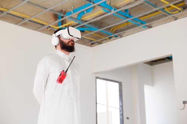 VR-Brille Arabischer Geschäftsmann und Bauingenieur mit 3D-VR-Brille Virtuelle Metaverse-Zukunftsinnenräume, die auf der Baustelle stehen