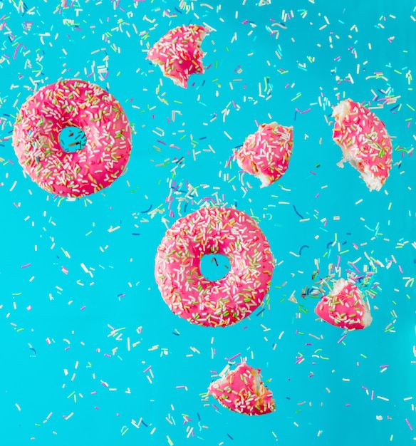 Vuela en donas de cereza de aire con cobertura en superficie azul.