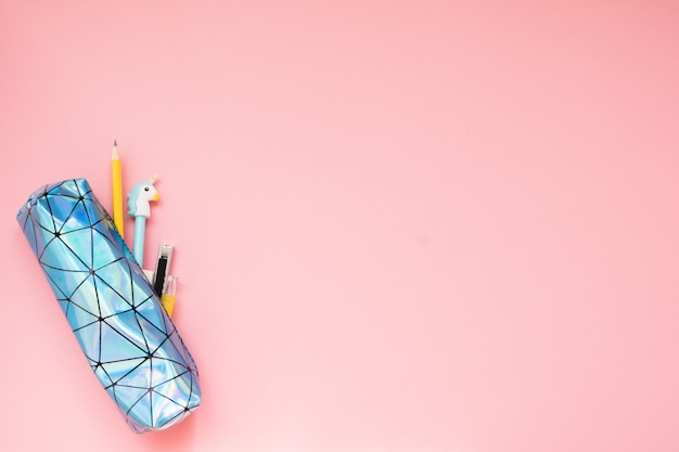 Foto de vuelta a la escuela. estuche con útiles escolares en mesa rosa