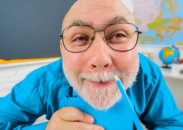 De vuelta a la escuela. Profesor divertido preparando la lección. Profesor universitario en vasos con lápiz. Aprendizaje y educación.