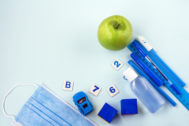 De vuelta a la escuela. útiles escolares y mascarilla médica.