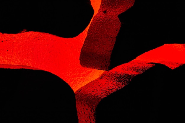 Vulcão vermelho brilhando através de rochas texturizadas em exibição