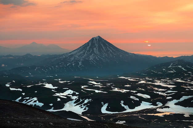 Vulcão Vilyuchinsky ao nascer do sol. Península de Kamchatka, Rússia. Céu rosa e montanhas cobertas de neve. Linda paisagem de verão