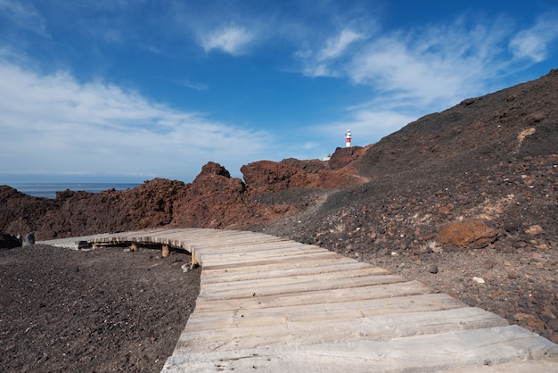 Vulkanische Landschaft Teneriffas und Leuchtturm im Hintergrund, Teno, Teneriffa, Kanarische Inseln