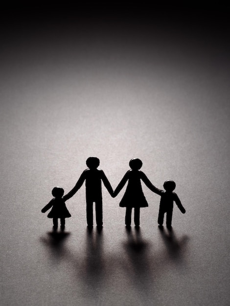 Vulnerabilidad de una familia tradicional Futuro impredecible y brumoso Lazos fuertes entre niños y padres Silueta de una familia sobre un fondo negro con espacio para copiar