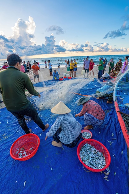 Vung Tau VIETNÃ 14 DE MAIO DE 2023 Pescador lançando sua rede ao nascer ou pôr do sol Pescadores tradicionais preparam a rede de pesca