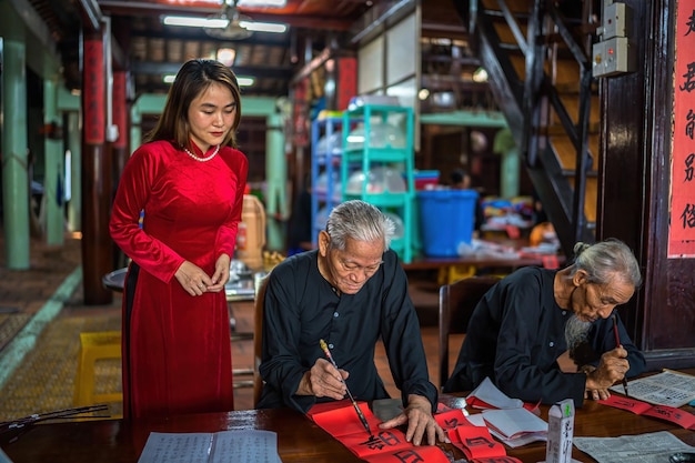 Vung Tau Vietnam 12 DE ENERO DE 2023 Un erudito vietnamita escribe caligrafía en el festival de caligrafía de Long Son es una tradición popular durante las vacaciones de Tet Escribir coplas para el Año Nuevo del Festival de Primavera