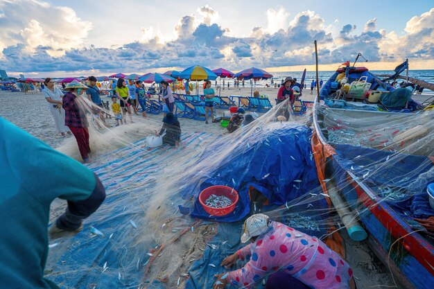 Vung Tau VIETNAM 14. MAI 2023 Fischer wirft sein Netz bei Sonnenaufgang oder Sonnenuntergang aus. Traditionelle Fischer bereiten das Fischernetz vor