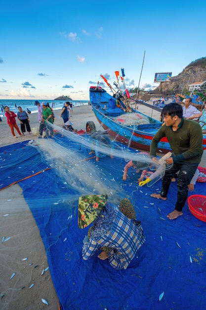 Vung Tau VIETNAM 14 DE MAYO DE 2023 Pescador lanzando su red al amanecer o al atardecer Los pescadores tradicionales preparan la red de pesca