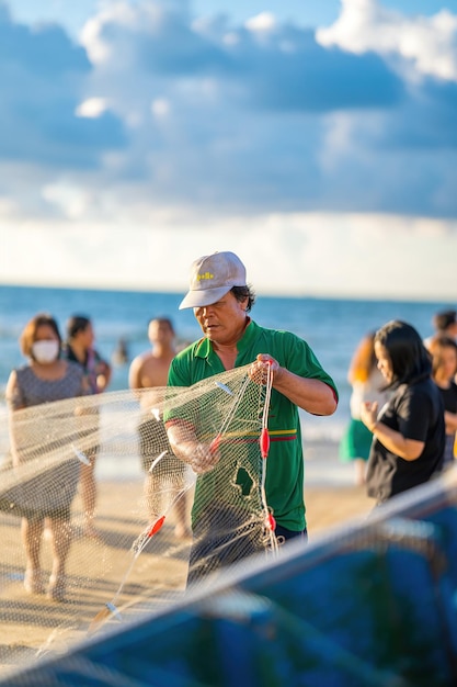 Vung Tau VIETNAM 14 DE MAYO DE 2023 Pescador lanzando su red al amanecer o al atardecer Los pescadores tradicionales preparan la red de pesca