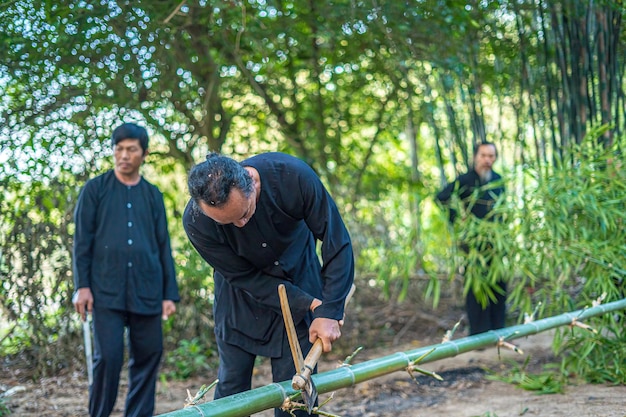 Vung Tau Vietnam 21 DE ENERO DE 2023 Grupo de enfoque anciano con un árbol de bambú tradicional vietnamita cortado para preparar Neu Tree El poste de bambú colocado frente a la casa el último día del año lunar