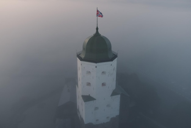 Vyborg Rusia 19 de septiembre de 2022 La cúpula de la torre de San Olaf39s en el castillo de VyborgLa bandera de la fortaleza ondea en el viento