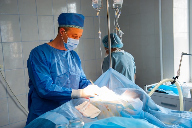 Wachsame Krankenschwester, die in einem modernen Operationszentrum eine Operation unter der hellen elektrischen Lampe durchführt