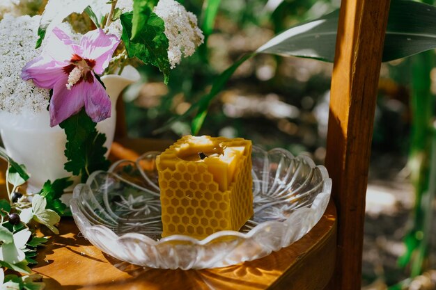 Wachskerze mit rustikalen Blumen auf Holztisch