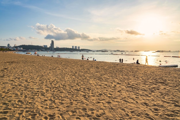 Wählen Sie den Fokus auf den Sand am Strand Wunderschöner tropischer Strand Meer Ozean Bucht herum und Architektur Gebäude in der Stadt Pattaya Thailand bei Sonnenuntergang