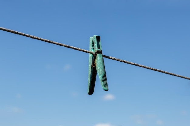 Wäscheklammer, die an einer Wäscheleine mit blauem Himmel hängt