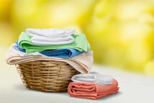 Wäschekorb mit bunten Handtüchern im Hintergrund