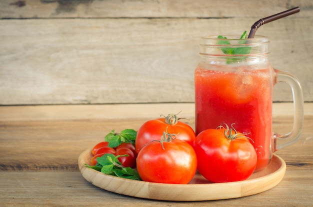 Wässern Sie Tomaten, rote Tomaten auf dem Holz.