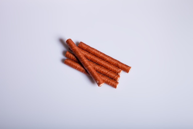 Waferrollen mit Schokolade auf weißem Hintergrund