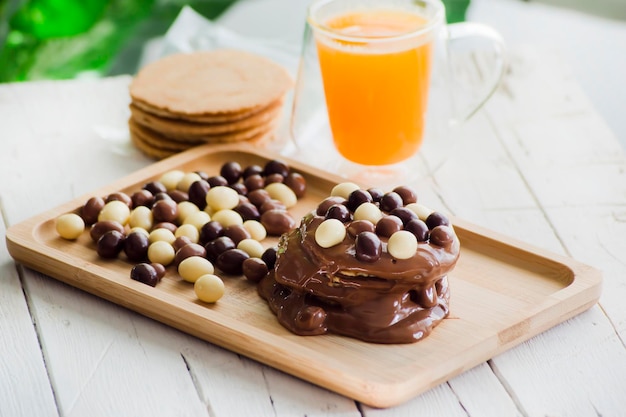 Wafers cobertos com creme de chocolate e bolas de chocolate e suco natural de laranja