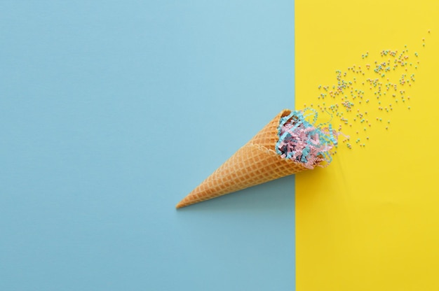 Waffelbecher mit hellen Streuseln und mehrfarbigem festlichem Hintergrund