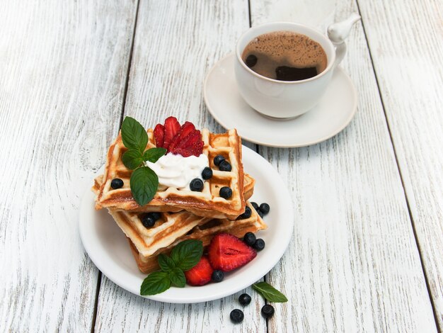 Waffeln mit Erdbeeren, Heidelbeeren und Kaffee