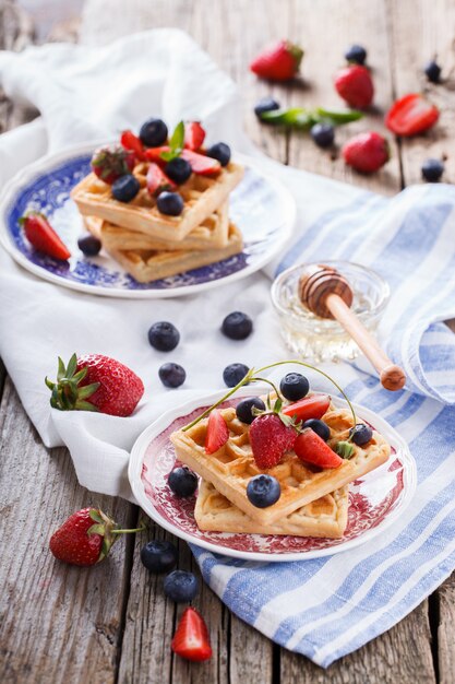 Waffeln mit Erdbeeren und Blaubeeren mit Honig