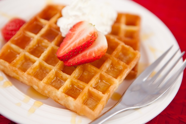 Waffeln mit Schlagsahne und Erdbeeren darauf