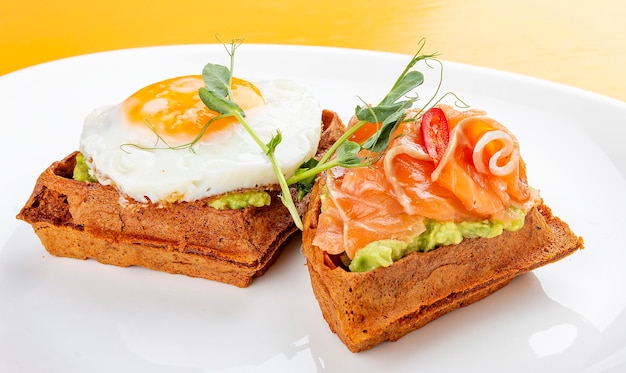 Foto waffle americano com salmão e ovo com mousse de abacate café da manhã saudável