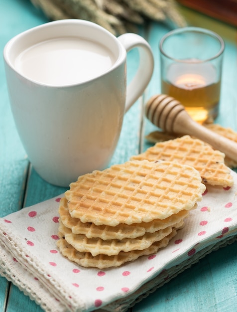 Waffle crujiente con miel en una mesa azul