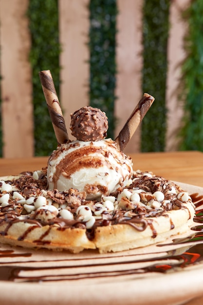 Foto waffle de sorvete delicioso com chocolate na mesa de madeira