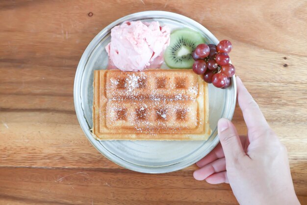 Waffle con helado y fruta o helado de fresa con uva waffle y kiwi