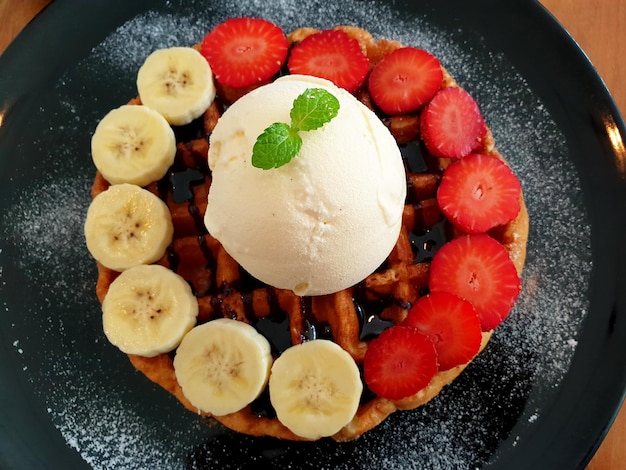 Waffle de plátano y fresa con postre helado de vainilla.