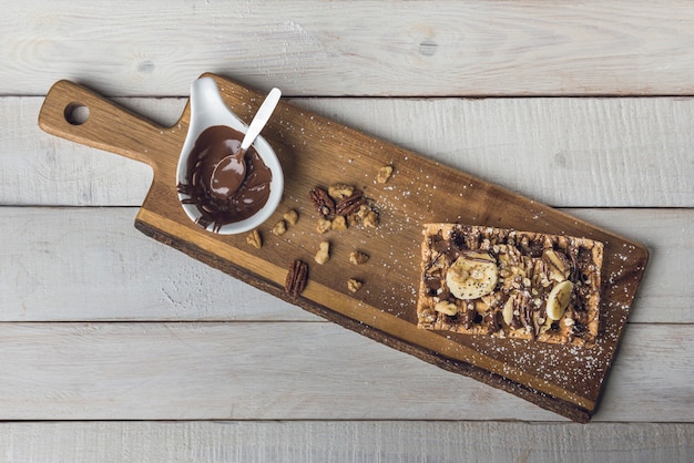 Foto waffle con rodajas de banana y chocolate